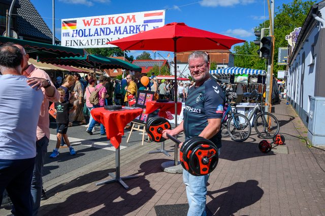 Hollandmarkt 2026: Ein Besucher mit einem orangefarbenen Helm unter dem Willkommensbanner