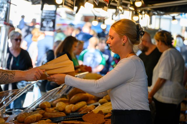 Hollandmarkt 2026: Eine Verkäuferin reicht Backwaren über die Theke
